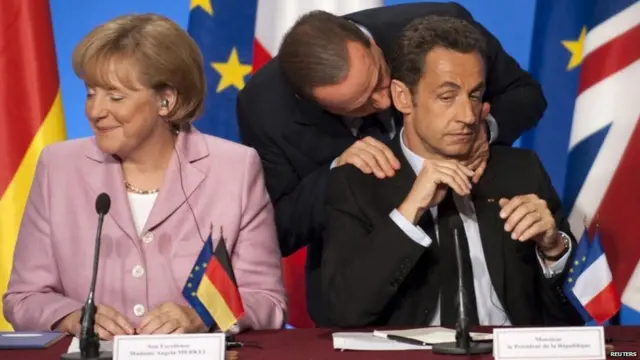 یورپی سربراہوں کی کانفرنسوں میں ان کے طرز عمل سے کئی آنکھیں ان کی جانب اٹھیں جیسا کہ اس تصویر میں سابق فرانسیسی صدر نکولس سارکوزی سے بات کر رہے ہیں جبکہ ان کے ملک میں قرضوں کا بحران سر اٹھا رہا تھا۔