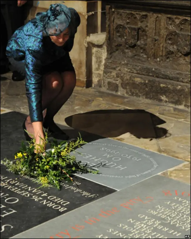 کارول، همسر تد هیوز، روی سنگ یادبود شوهرش گل گذاشت؛ گل هایی که از باغ خانه ای که با هم در آن زندگی می کردند، چیده بود.
