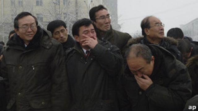 Hombres norcoreanos lloran ante el paso del cortejo fúnebre.
