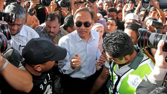 Nhà lãnh đạo đối lập Anwar Ibrahim (giữa) và vợ ông, bà Wan Azizah (phía sau) đến tòa để nghe án lệnh. Vào đêm trước khi tòa tuyên án, ông Anwar nói ông đã chuẩn bị tinh thần sẽ bị ngồi tù. Án này đe dọa sự nghiệp chính trị của ông mấy năm qua.