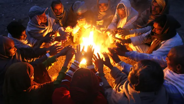 चंडीगढ़ की ठंडी रात में आग सेंकर कुछ गर्माहट भरते लोग. तस्वीर- रॉयटर्स