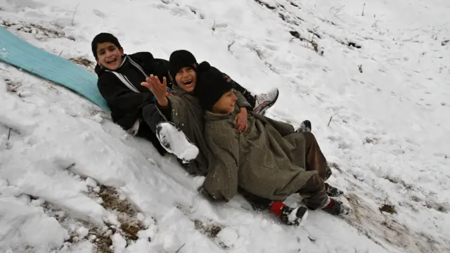 कुछ लोगों के लिए बर्फ़बारी परेशानी का सबब है तो इन बच्चों के लिए मस्ती का बहाना. तस्वीर- एपी