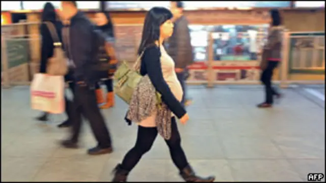 Seorang ibu hamil berjalan di Hong Kong