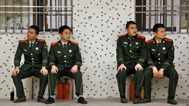 Nhân viên cảnh sát giám sát người dân làng trong khi diễn ra cuộc bầu cử. 