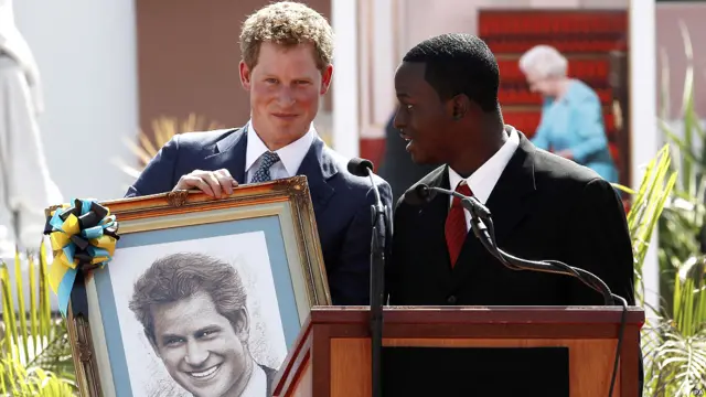 哈里王子在巴哈首都拿骚举行的一次露天欢迎仪式上接受当地艺术家Jamaal Rolle为他创作的肖像。