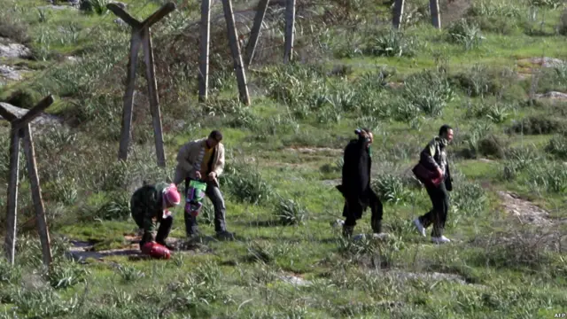 Sekelompok warga Suriah menerobos pagar berduri menuju Turki