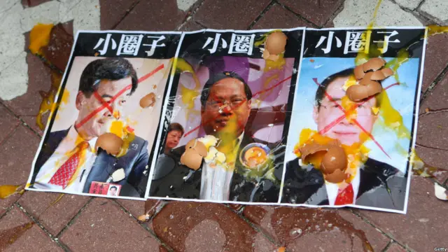 抗议者向三位候选人的图像扔鸡蛋