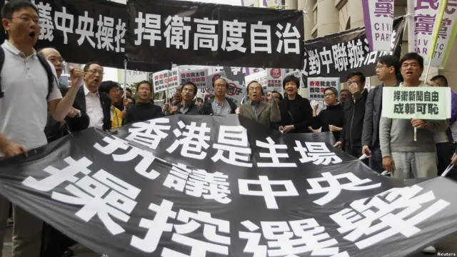 示威者手举标语抗议中央操控选举。