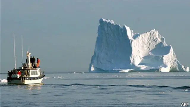 Un barco pasa junto a un iceberg cerca de Groenlandia.
