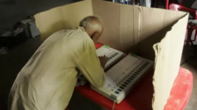 ඉන්දියානු ඡන්දදායකයෙක් යන්ත්‍රයක් මගින් ඡන්දය පාවිච්චි කරමින් 