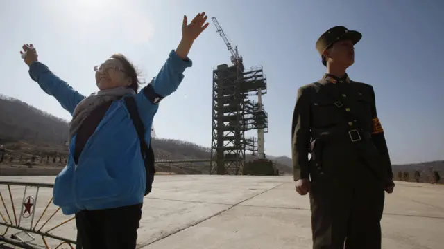 Một khách tham quan tạo dáng chụp hình trước tên lửa Unha-3. Bắc Hàn đã thực hiện một vụ tương tự hồi năm 2009.