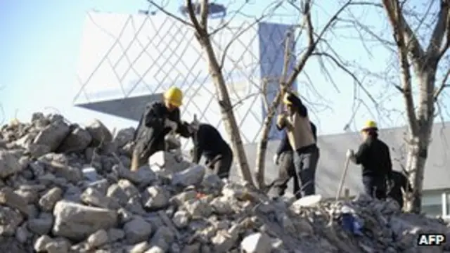 北京某拆迁工地工人在拆卸墙壁(资料图片)