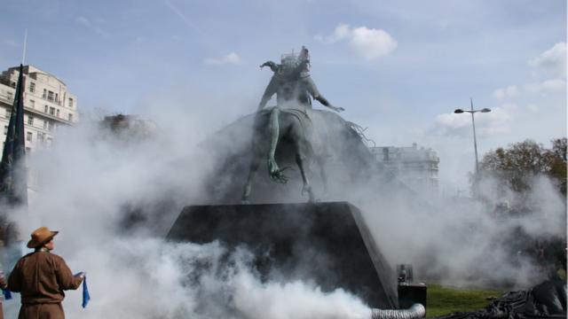 Памятник окуривают дымом. 
