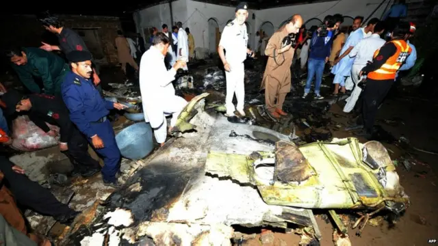 Tempat duduk pesawat, perhiasan dan benda lainnya berserakan di antara rongsokan pesawat.