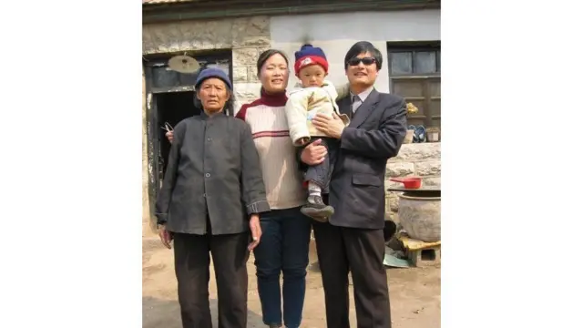 Ông Trần, chụp cùng với gia đình tại tỉnh Sơn Đông quê hương ông, đã vận động chống lại việc phụ nữ bị buộc phải phá thai hoặc triệt sản theo chính sách một con của Trung Quốc. Ông bị bỏ tù bốn năm hồi năm 2006 vì làm mất trật tự giao thông và phá hoại tài sản.  