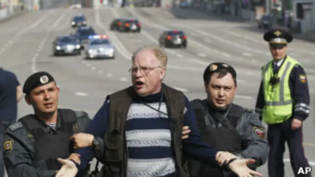 Задержание протестующего на фоне кортежа Путина