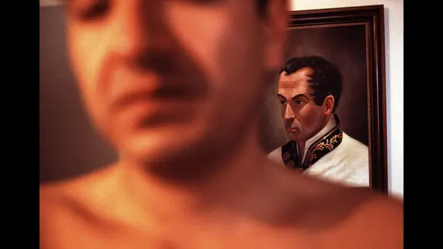 Un exsecuestrado posa frente a un cuadro de Bolívar. Bogotá, mayo 2001. Foto: Stephen Ferry