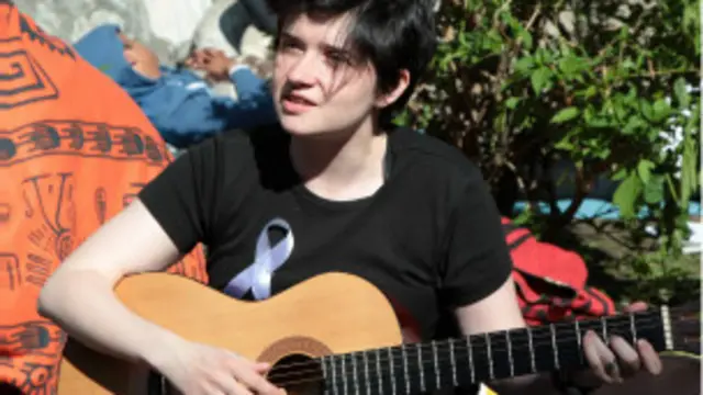 Вокалистка и актриса Яна Фальк играет на гитаре и поет для собравшихся на Чистопрудном бульваре