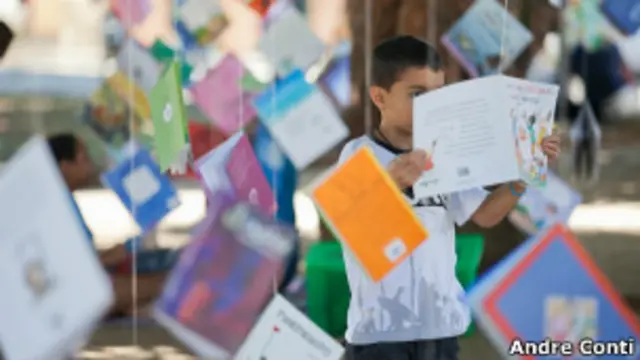 Criança brinca com livros na Flip (Foto: André Conti)