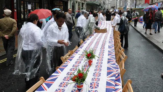 工作人员冒雨在伦敦市中心皮卡迪利布置餐桌