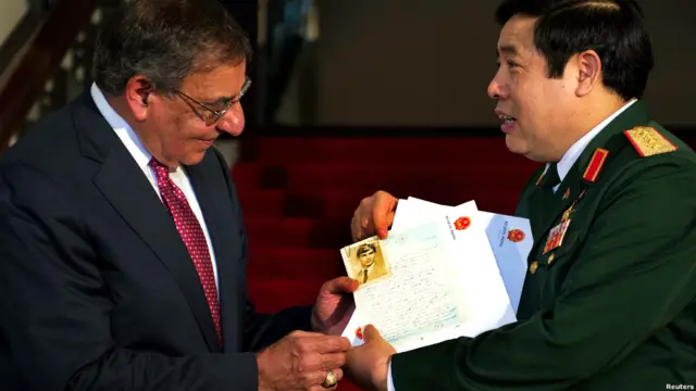 Hai vị bộ trưởng quốc phòng trao đổi kỷ vật của hai người lính đã ngã xuống trong chiến tranh.