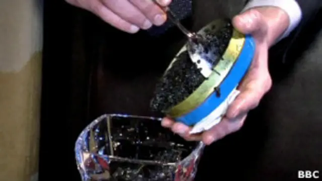 Мужчина накладывает черную икру