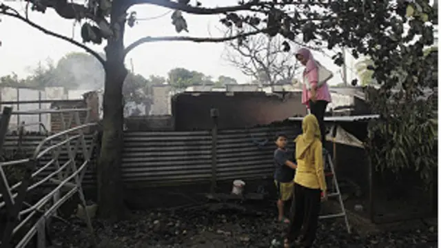 Warga menyaksikan sisa reruntuhan rumah yang terbakar setelah tertimpa pesawat Fokker 27 milik TNI AU.
