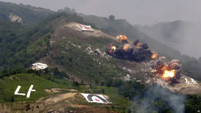 韩国抱川市升进训练场美韩联合军演现场一面朝鲜国旗旁冒起了农烟（19/6/2012）