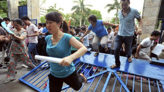 Phụ huynh xô đổ cổng sắt và tràn vào trường để lấy mẫu hồ sơ xin học vì đây được coi là trường tốt và có học phí rẻ hơn nhiều trường khác tại Hà Nội.