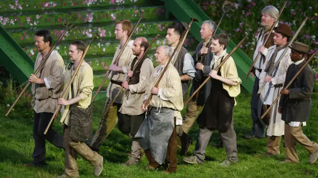 农夫们扛着锄头去耕田。