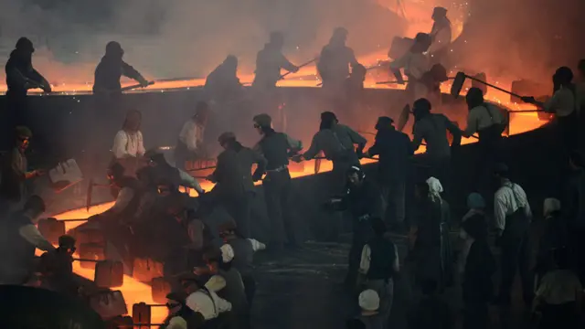 演员们扮演的工人们艰苦地工作。