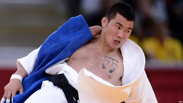 Moğol judocu Kaşbahar, çift ayak iziyle "Şampiyon yazan dövmesini maç sırasında açık ediyor.