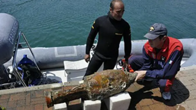 Seorang penyelam menunjukkan benda yang ditemukan di dalam bangkai kapal Romawi tersebut.