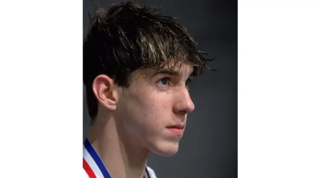 سنہ دو ہزار میں لی گئی اس تصویر میں چودہ سالہ امریکی تیراک مائیکل فیلپس ہیں۔ مائیکل اس وقت باسکٹ بال کے سٹار مائیکل جورڈن سے بہت متاثر تھے۔ فیلپس اولمپکس کھیلوں میں سب سے زیادہ میڈل حاصل کرنے والے کھلاڑی ہیں۔ انہوں نے بائیس تمغے جیتے ہیں جن میں سے اٹھارہ طلائی تمغے ہیں۔ 