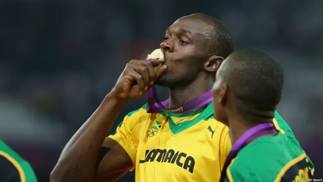 Usain Bolt mencium medali emas