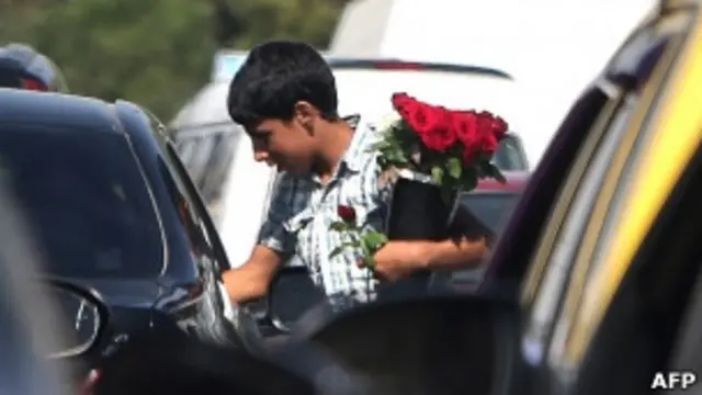 Сирийский подросток продает цветы водителям на проезжей части дороги