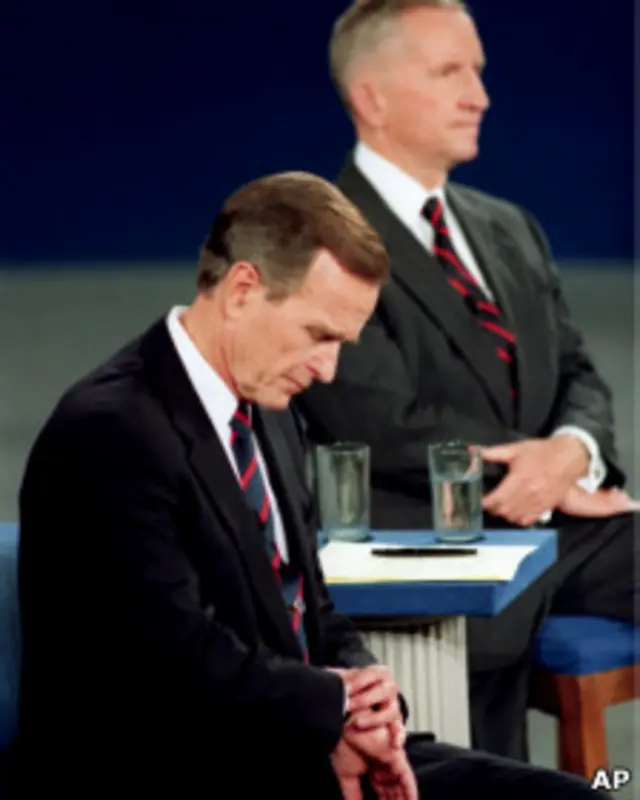 George Bush mira su reloj durante el debate con Clinton y Perot
