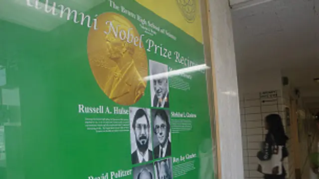 स्कूल के प्रेवश द्वार पर पोस्टर लगा है जिसमें नोबेल विजेताओं की तस्वीरें हैं.