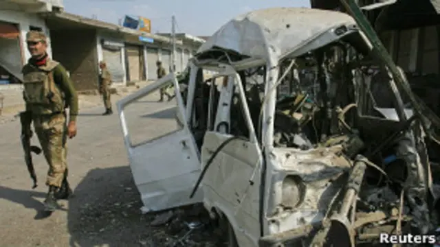 Полицейский у взорванной машины в пакистанском городе Дарра Адам Хель