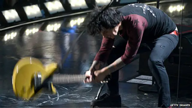 Hombre rompiendo guitarra