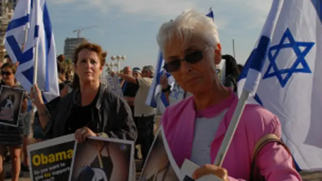 Женщины с лозунгами в адрес Обамы и флагами Израиля