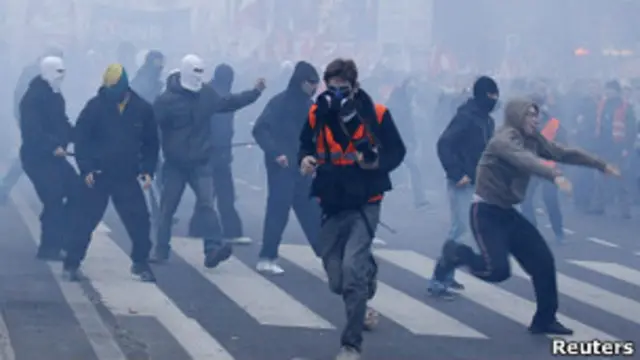 Люди в масках бросают булыжники