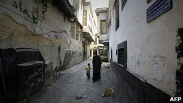 Una mujer pasea con un niño por las calles de Damasco