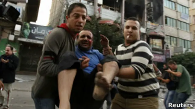 Палестинцы несут раненого мужчину