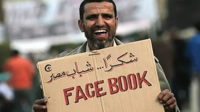 Manifestante con cartel de Facebook