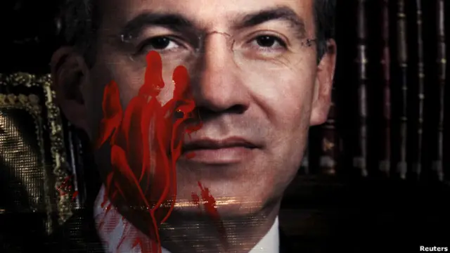 Foto de Felipe Calderón manchada con pintura roja.