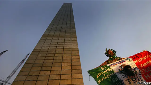 Manifestante sostiene bandera mexicana a los pies del monumento Estela de Luz.