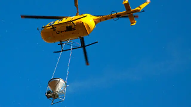 Helicóptero con un recipiente que transporta cebos letales para las ratas Foto: Martin Collins