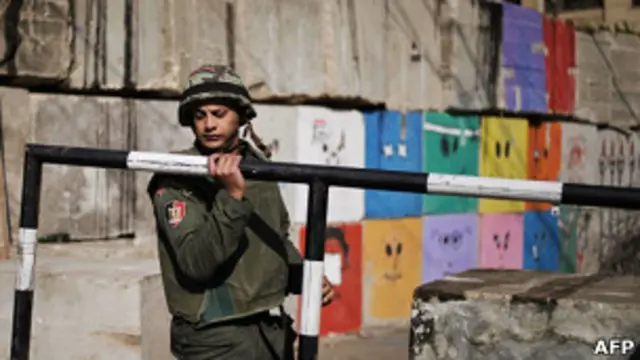 Солдат египетской армии убирает ограждение президентского дворца в Каире