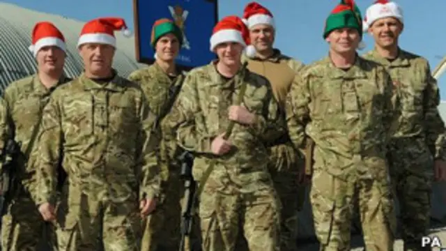 Солдаты в хаки и колпаках Санта-Клауса